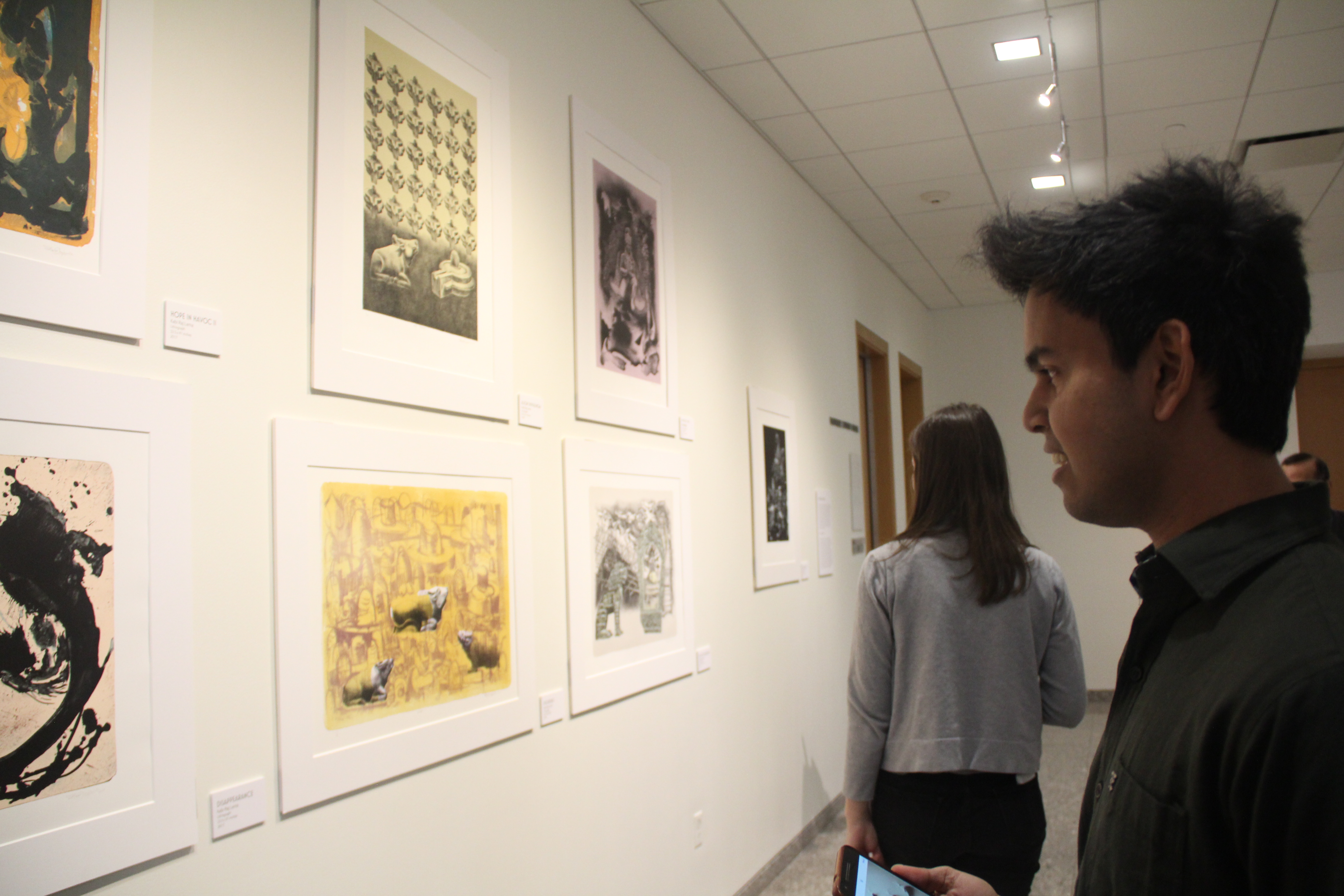 An attendee looks at Kabi Raj Lama's work during the opening reception.