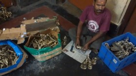 An artisan working on a brass product in Anwesha
