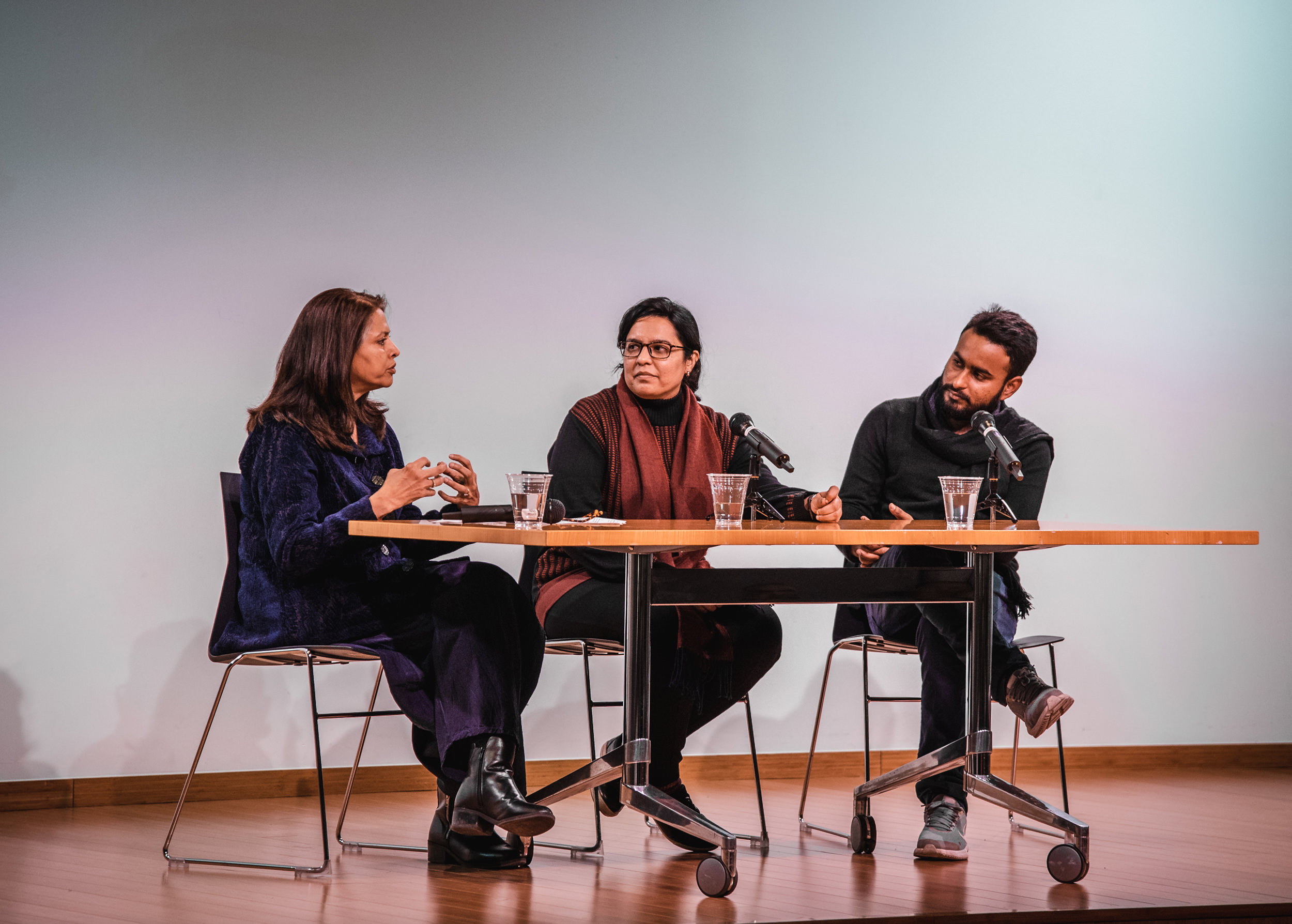 From left to right: Meena Sonea Hewett discusses the work of Krupa Makhija and Mahbub Jokhio on stage.