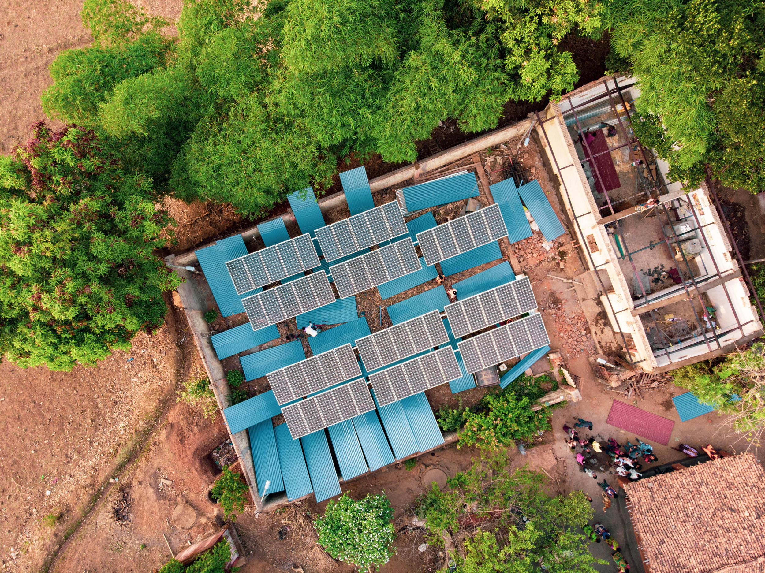 A drone shot of the construction site. Newly painted roofing sheets dry among the solar panels. Photo credit: Ajaya Behera.